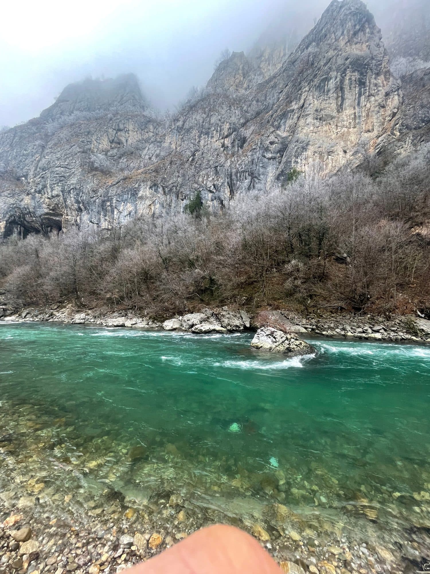 Steep canyon walls rising above a green river